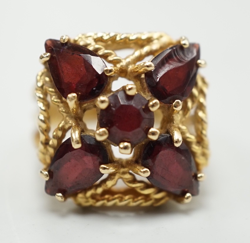 A modern 585 yellow metal and five stone garnet cluster set dress ring, size K/L